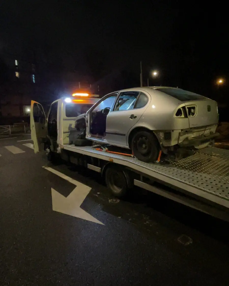 Dépanneuse B2A de nuit, gyrophare allumé, avec une voiture accidentée sur le plateau